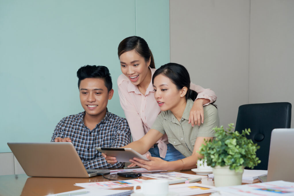malaysian employees discussing with a laptop ang tablet