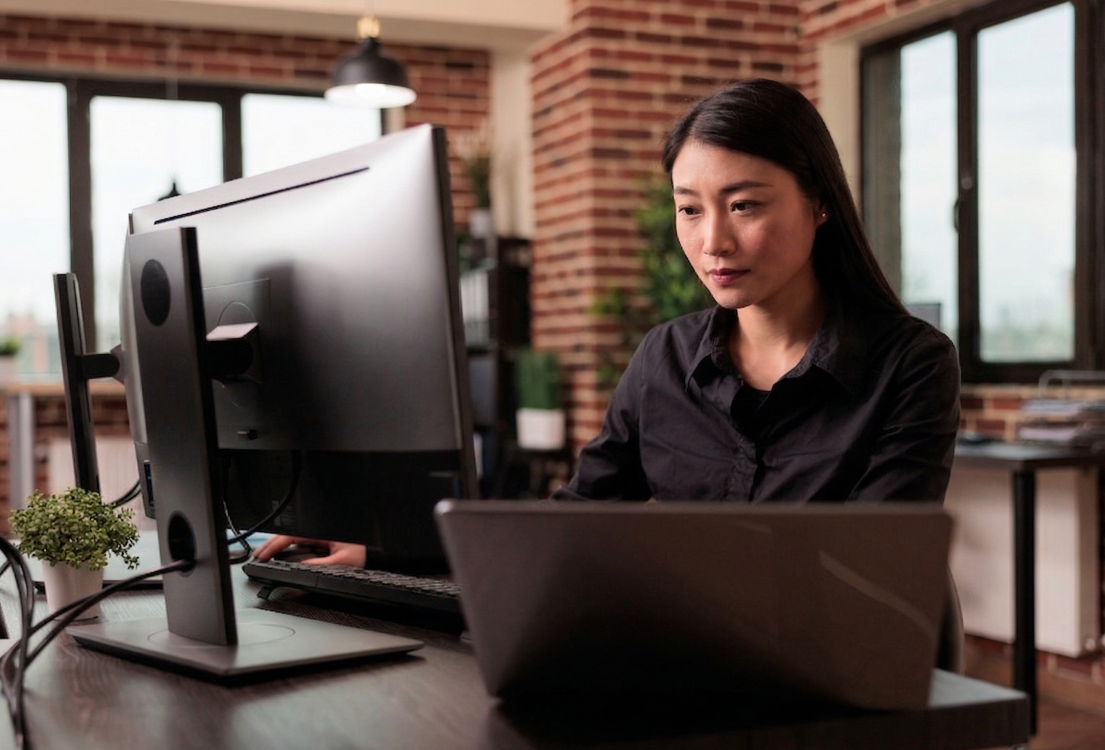 vietnamese web developer actively programming in adual monitor setup