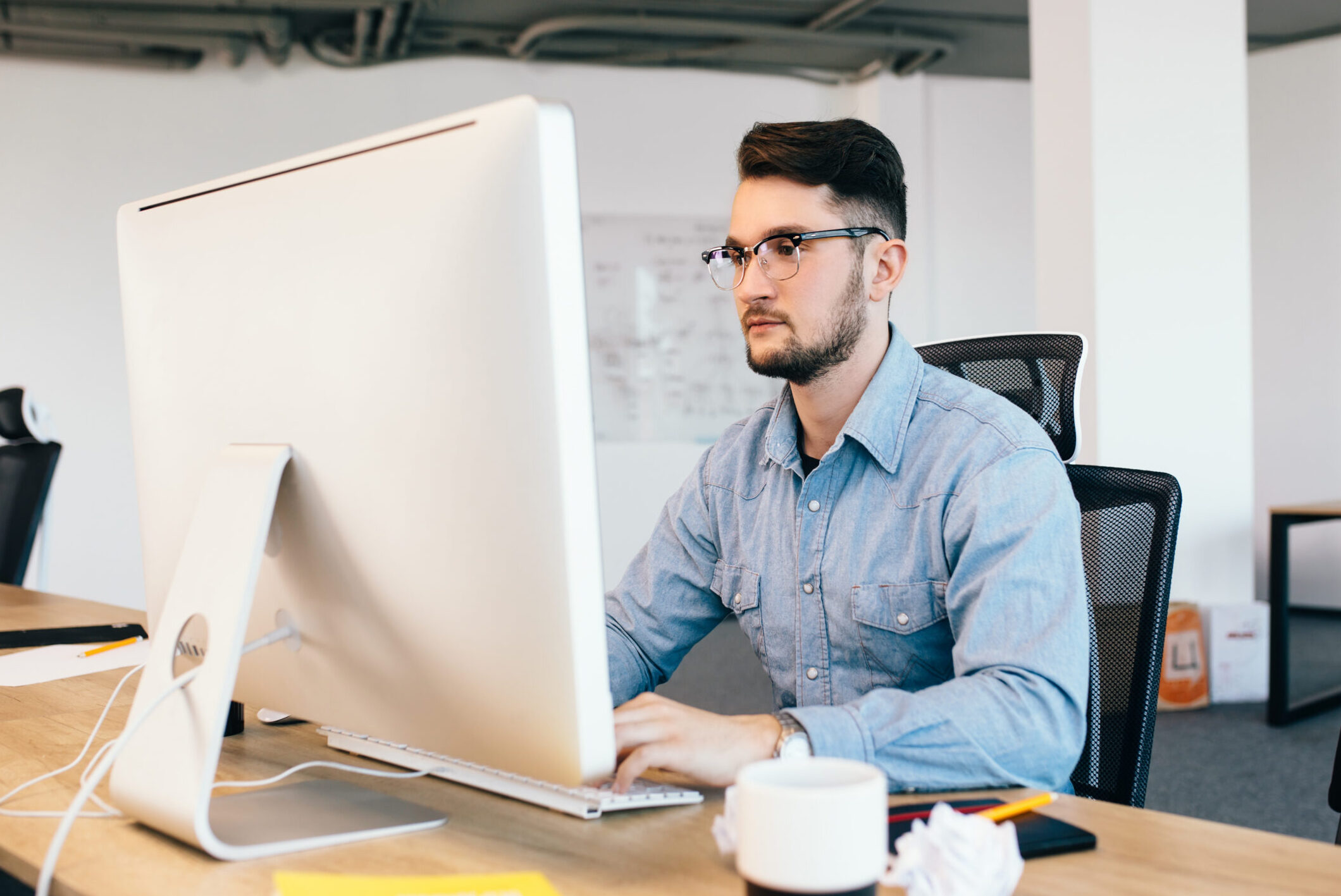 web developer in argentina working in a industrial type office with a monitor on the desk