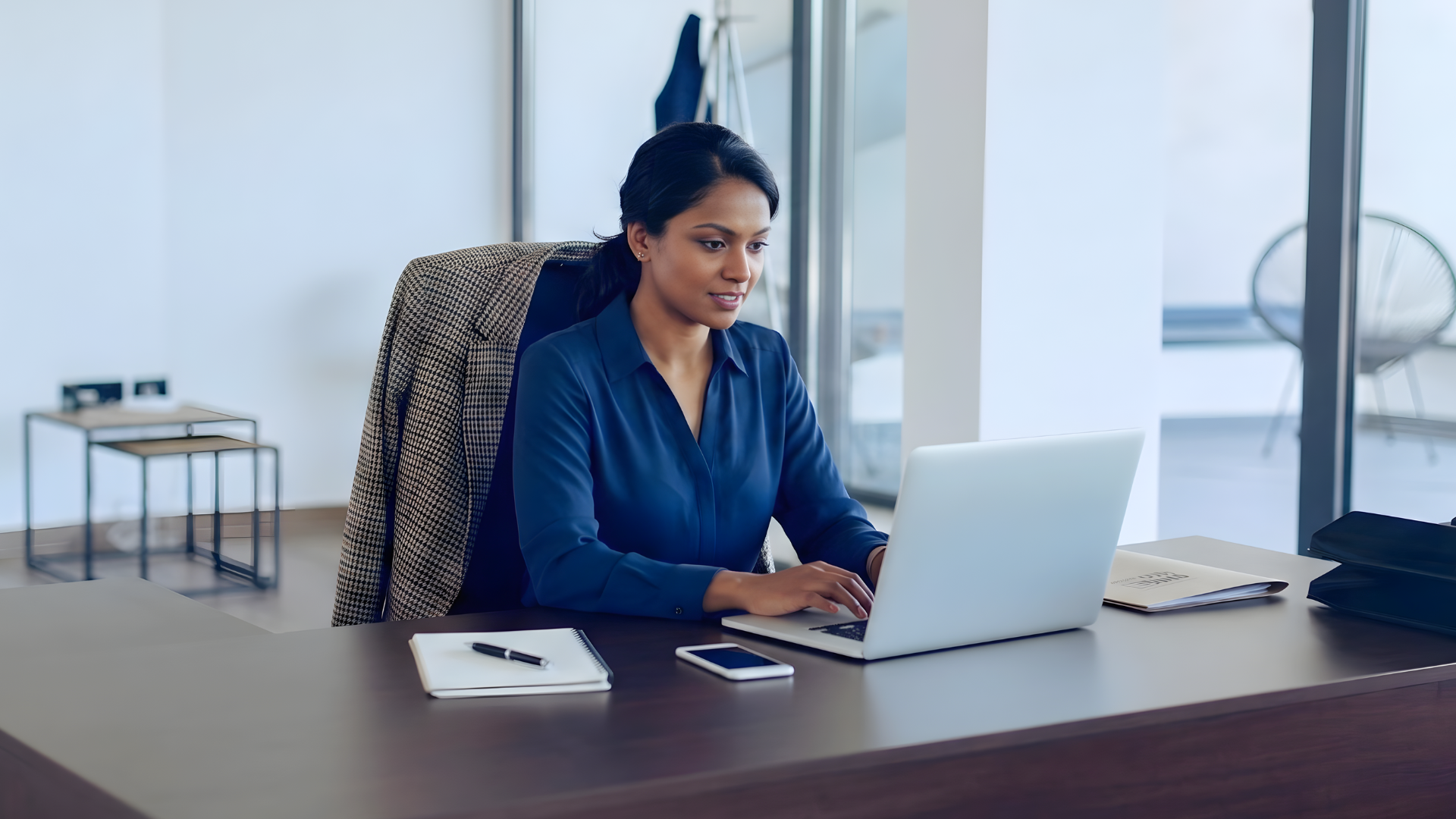 indian offshore operations manager seriously working on a bright office