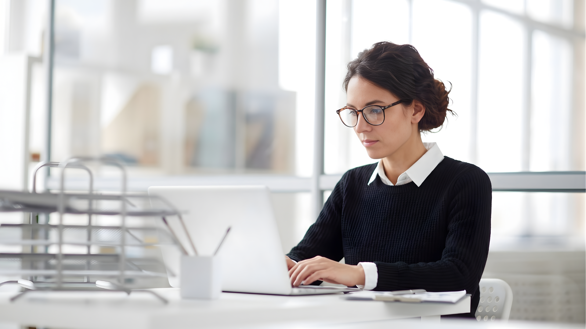 outsourced offshore internal auditor working focused working with a laptop in a bright office