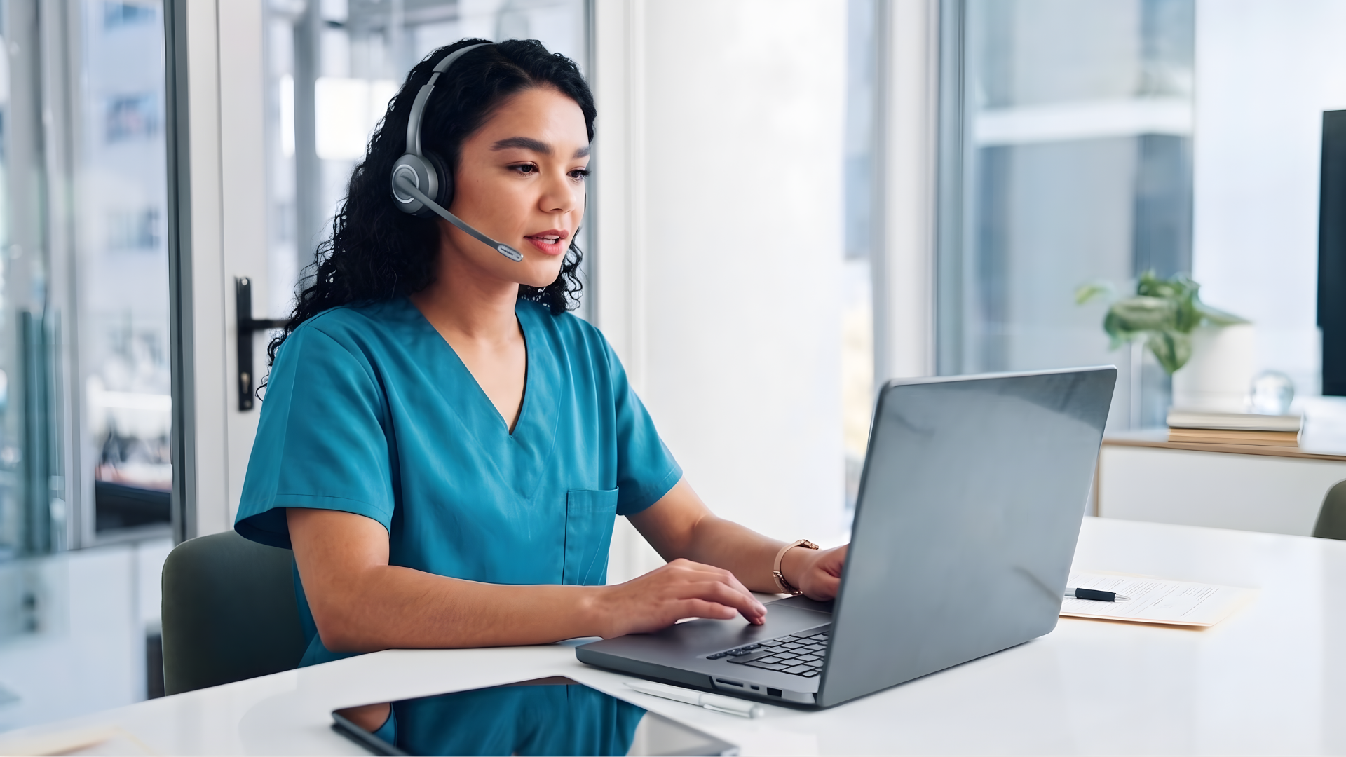 virtual medical administrative assistant typing information in a laptop