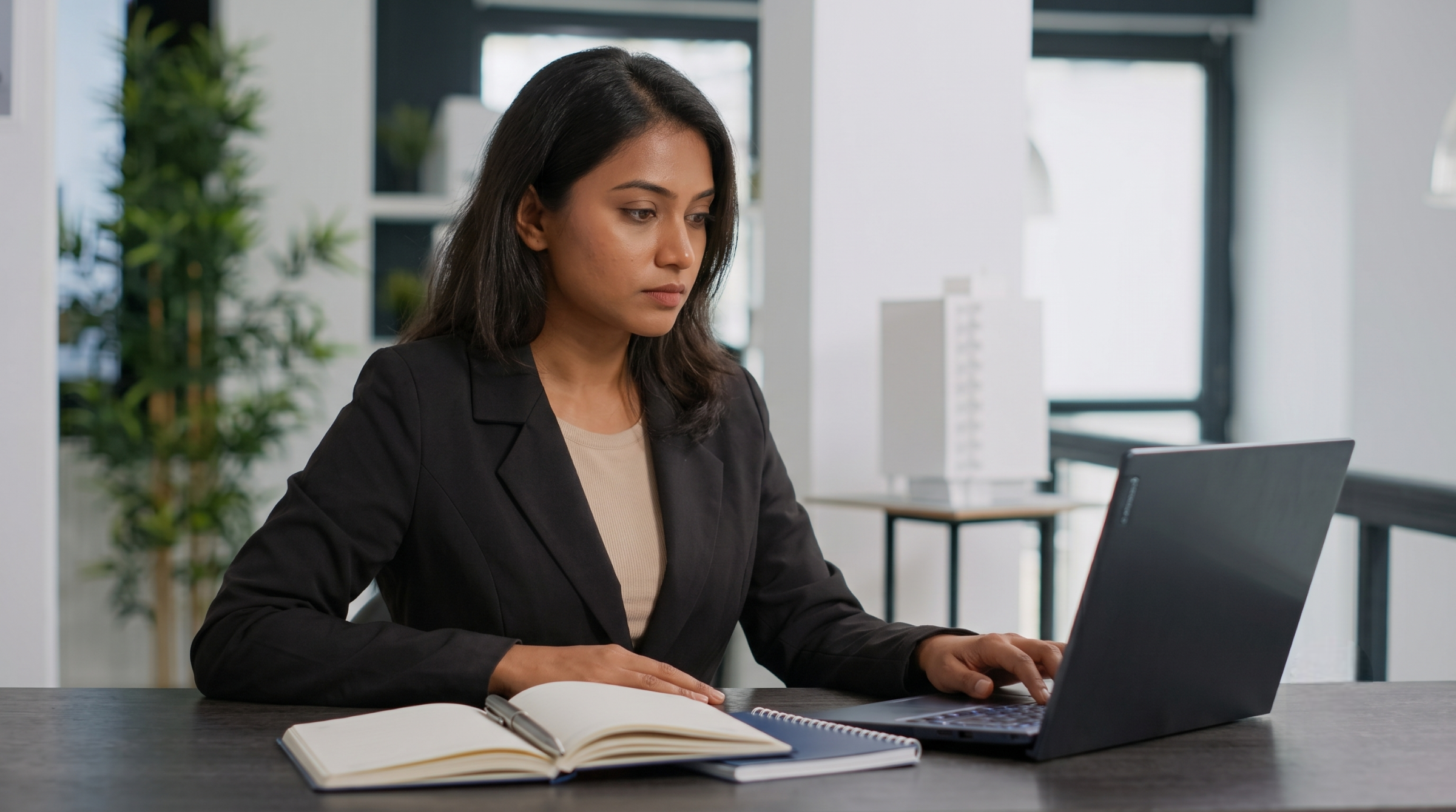 offshore legal operations specialist reviewing documents on a laptop in India