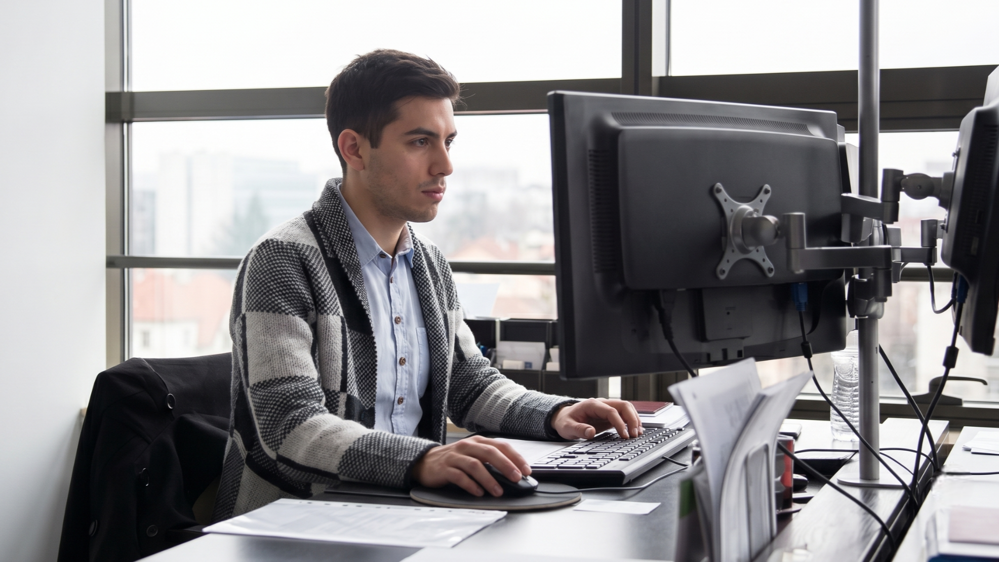 remote cloud engineer in Argentina focused on his work while using dual monitors at his desk