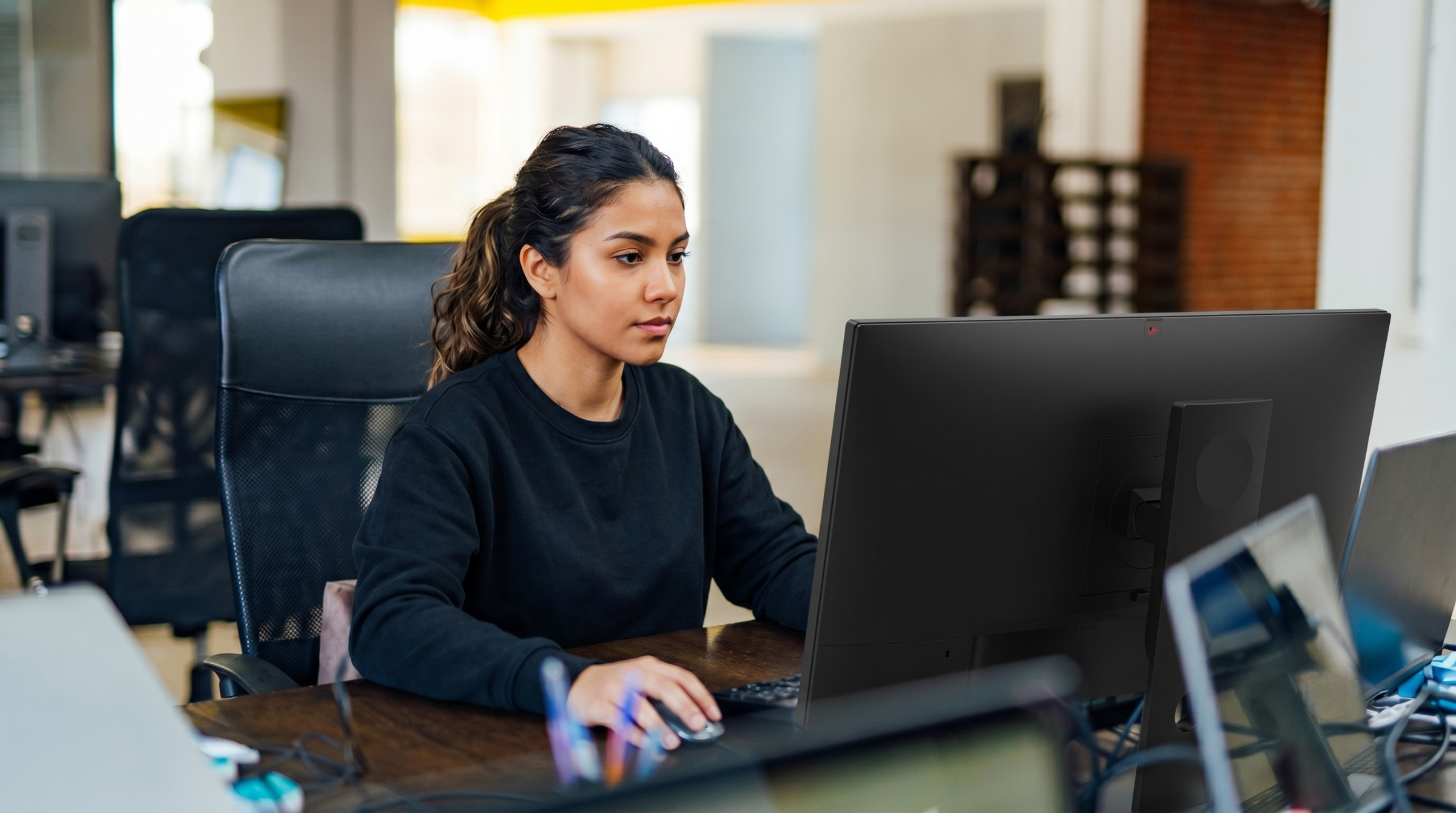 professional leveraging an outsourced cloud engineer in Colombia to manage technical infrastructure from an office desk