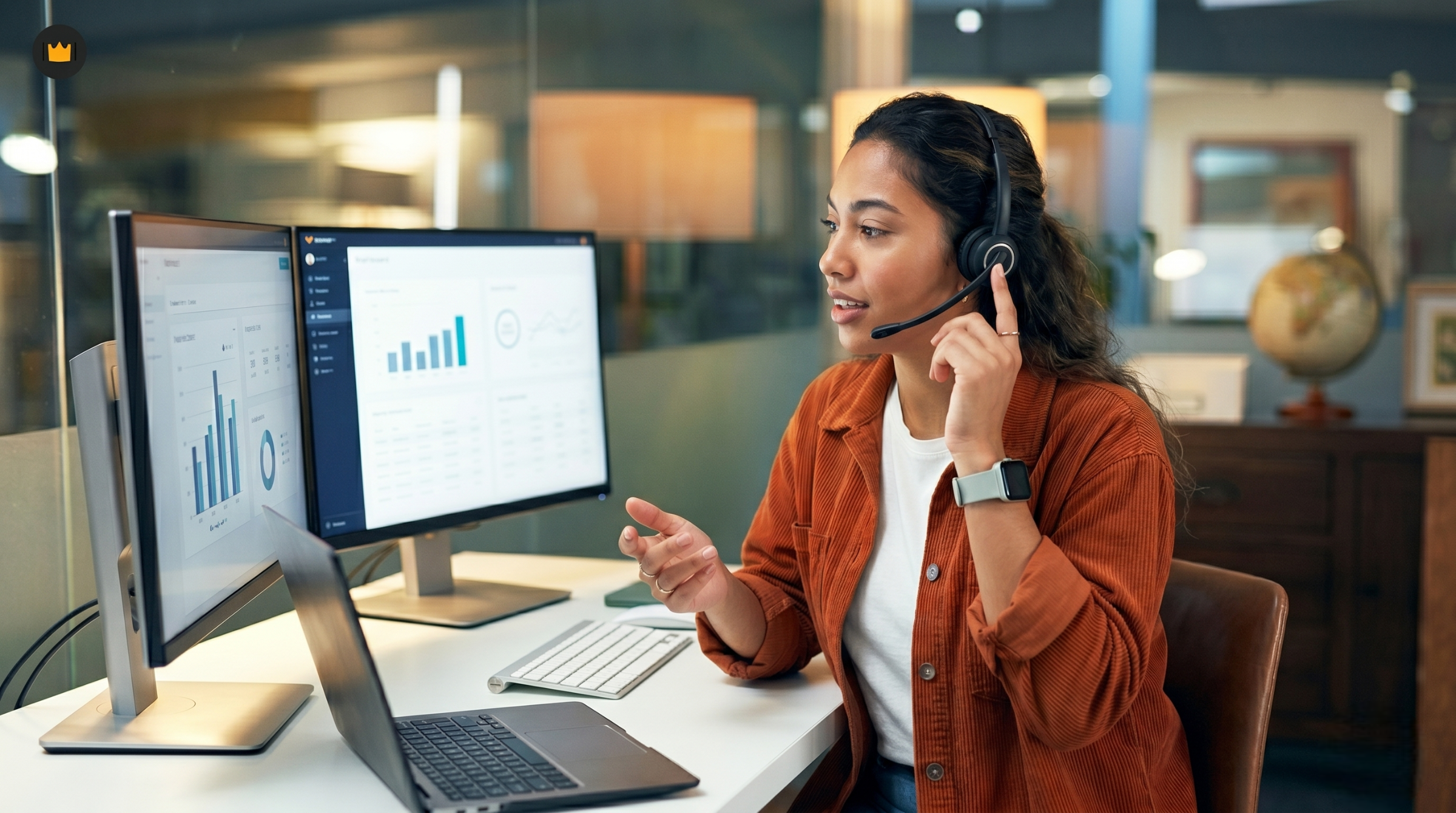 A latina outsourced logistics coordinator in Colombia managing supply chain metrics across dual monitors while on a video call