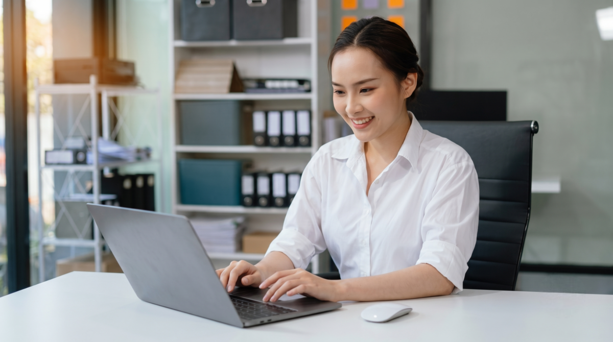 smiling female outsource payroll officer focused on her work at a modern desk