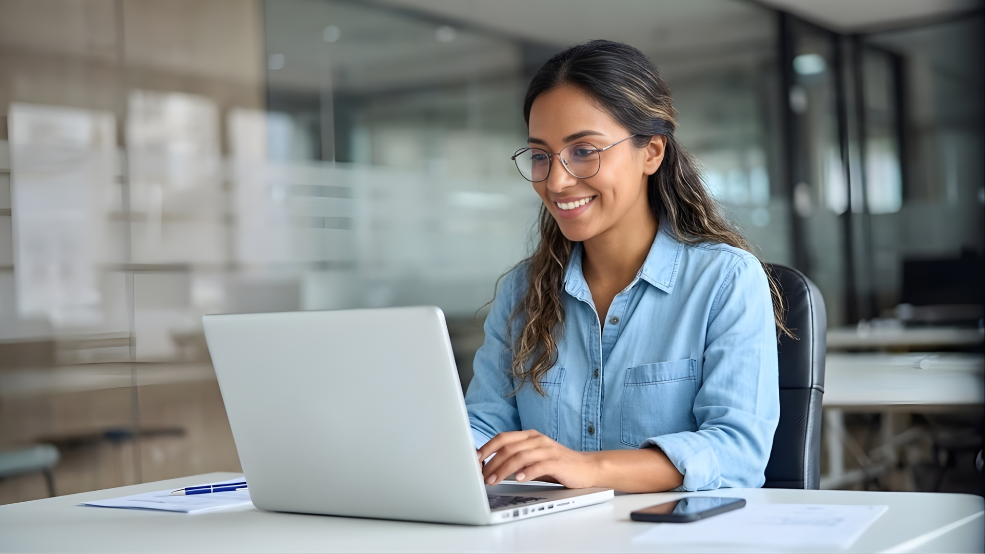 a smiling virtual salesforce developer in Colombia collaborating thru a laptop in a modern office space