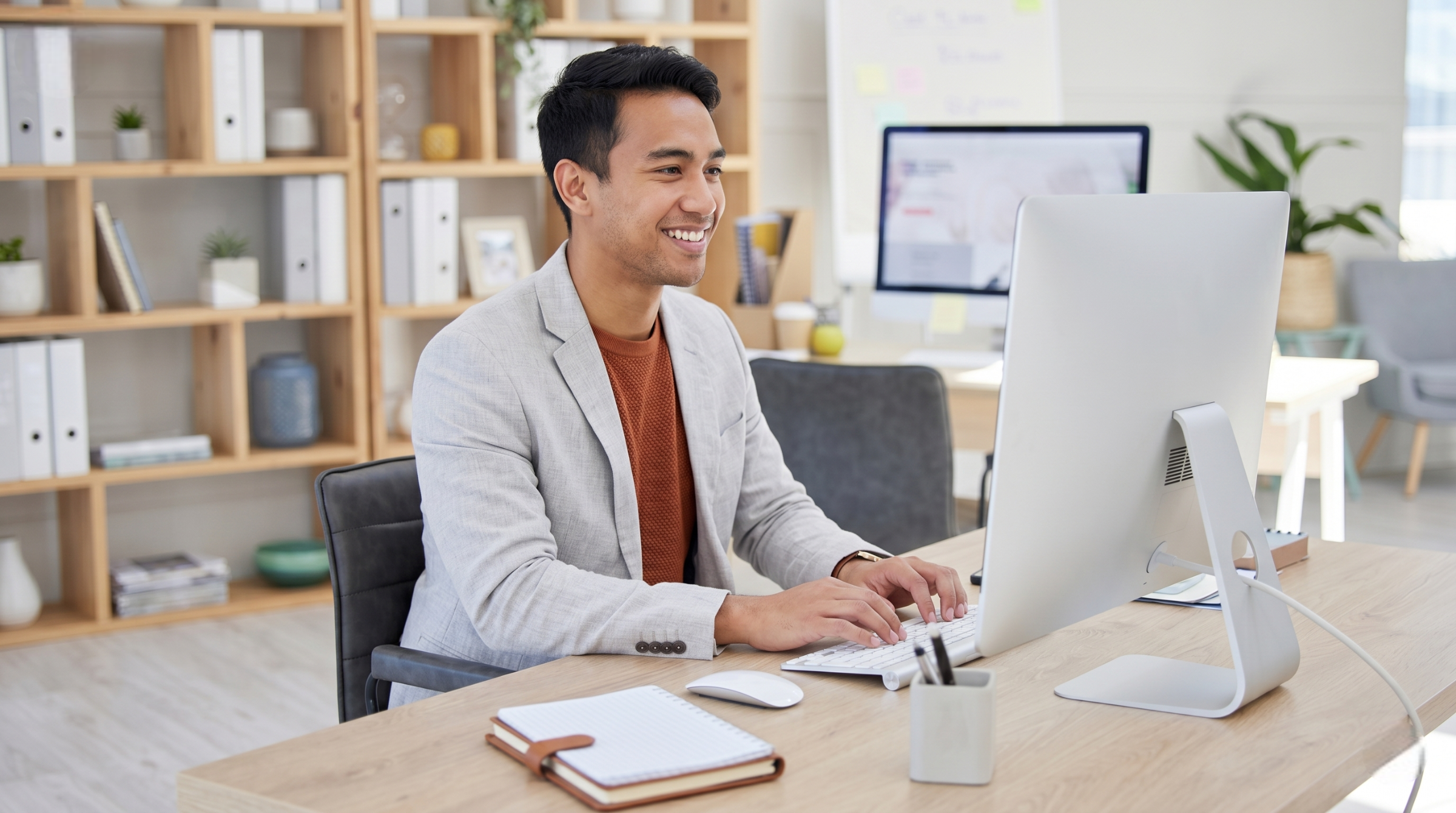 smiling professional providing supply chain planning services from a clean, organized office in Malaysia