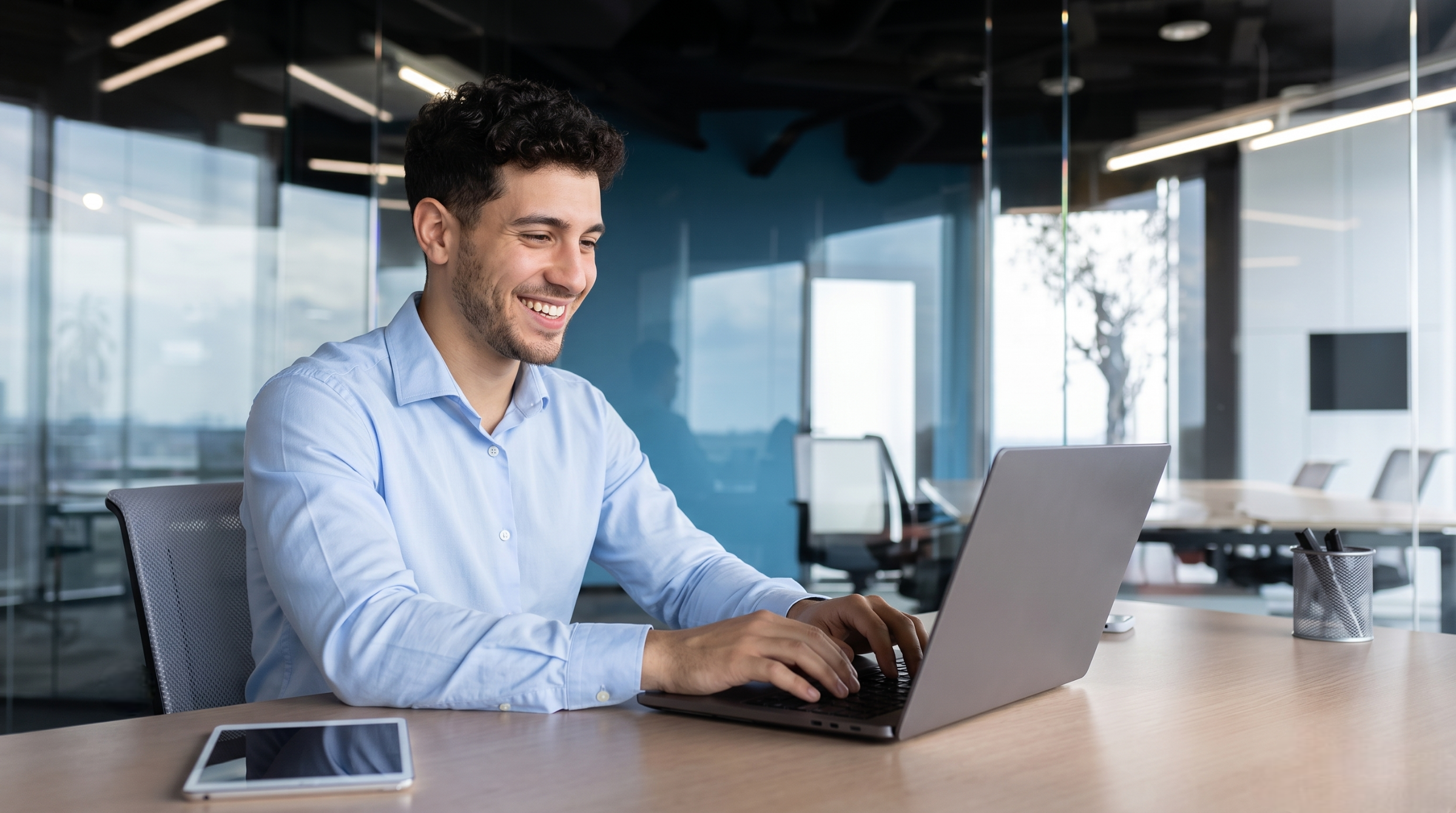 Smiling man at laptop working as an outsourced SEO specialist