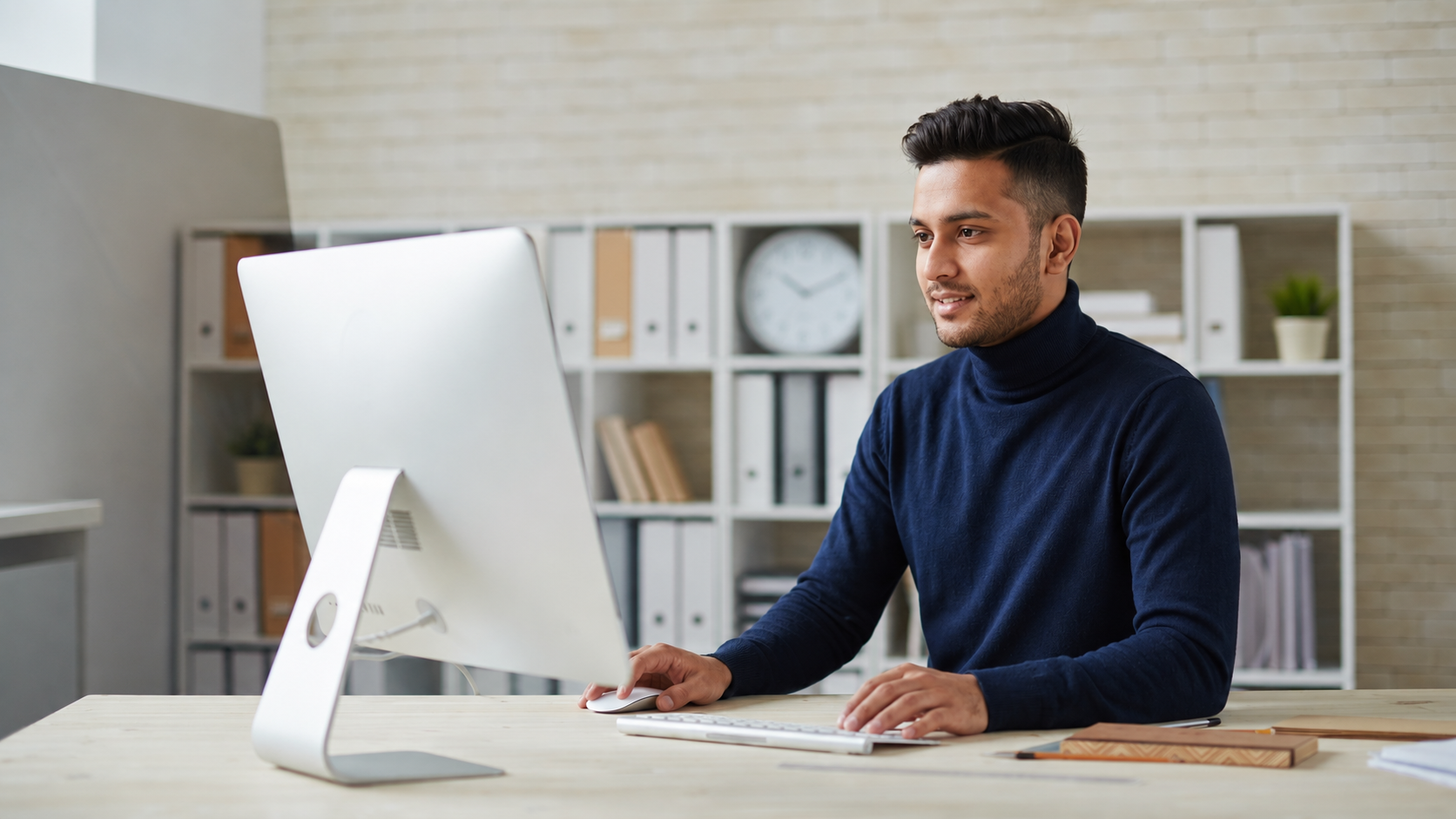remote autocad designer working on a sleek white computer in an organized office