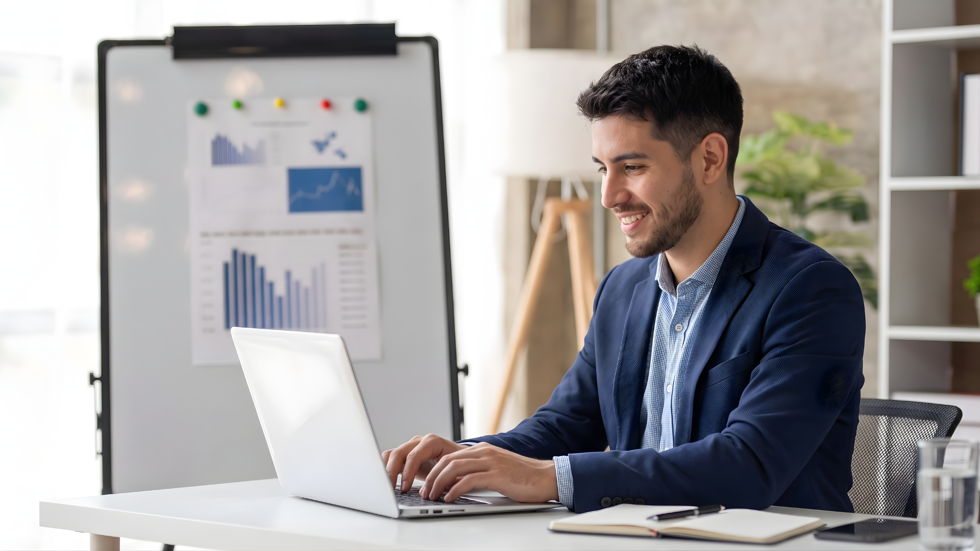 professional managing outsourcing quality control tasks on his laptop in front of a whiteboard with charts