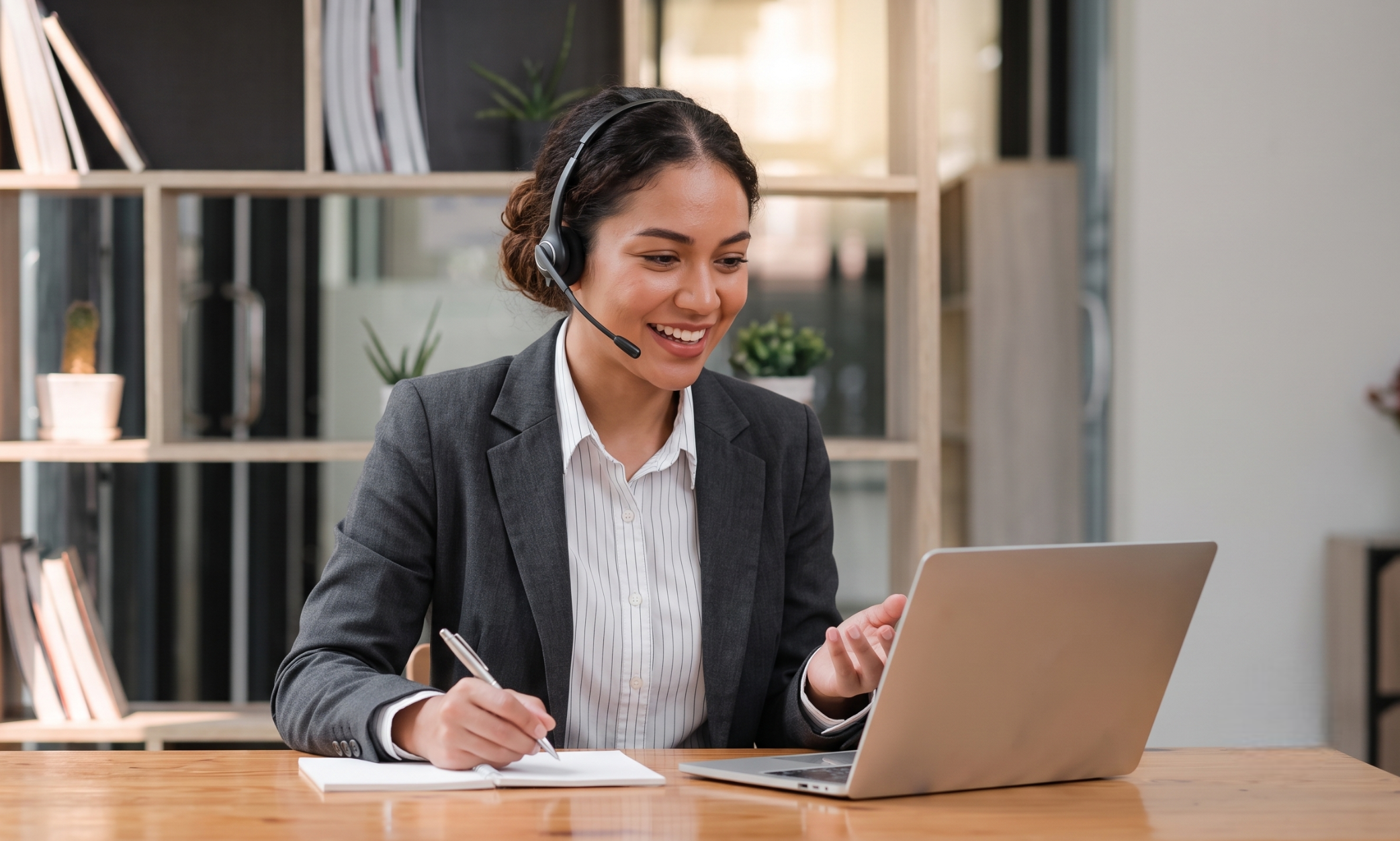colombian outsourced telemarketing agent with an upbeat attitude is working in her office with a headset