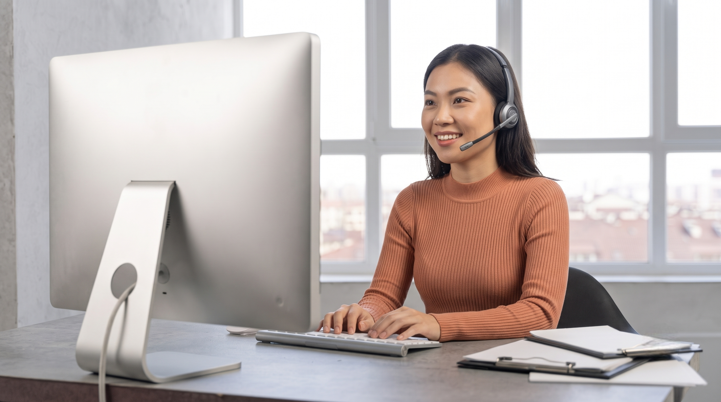A smile on her face, a virtual telemarketer from Vietnam takes calls in front of her computer