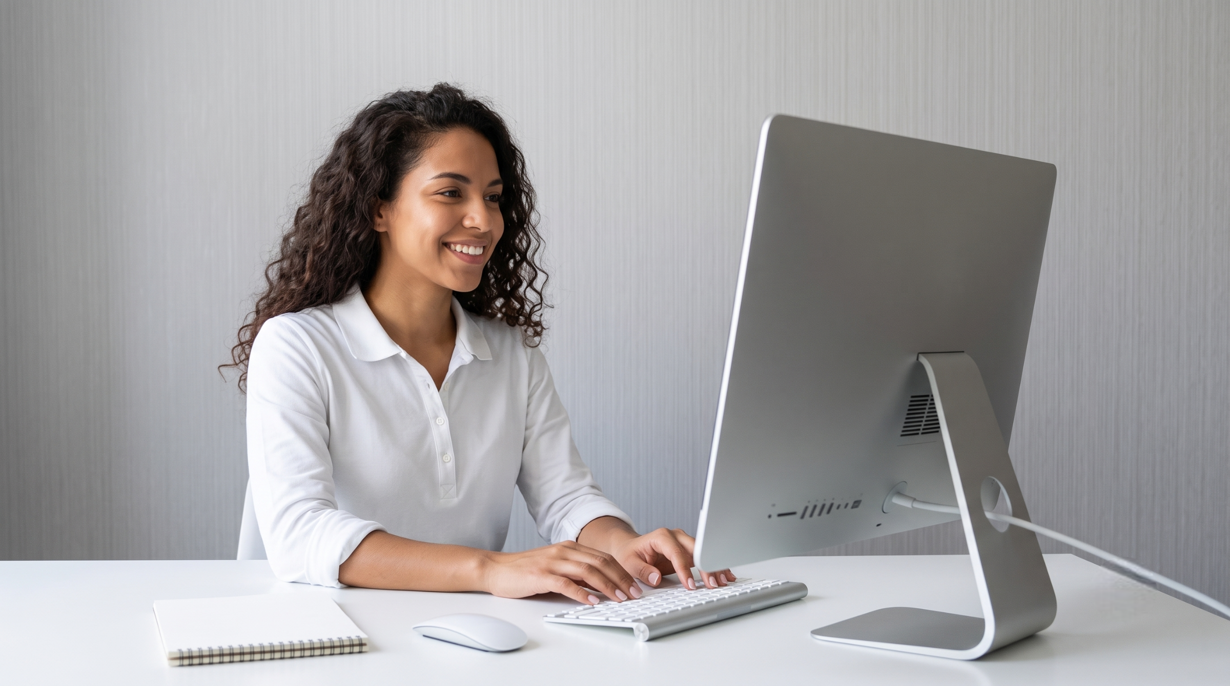 professional demand planner remote typing on a desktop computer keyboard at a bright white desk
