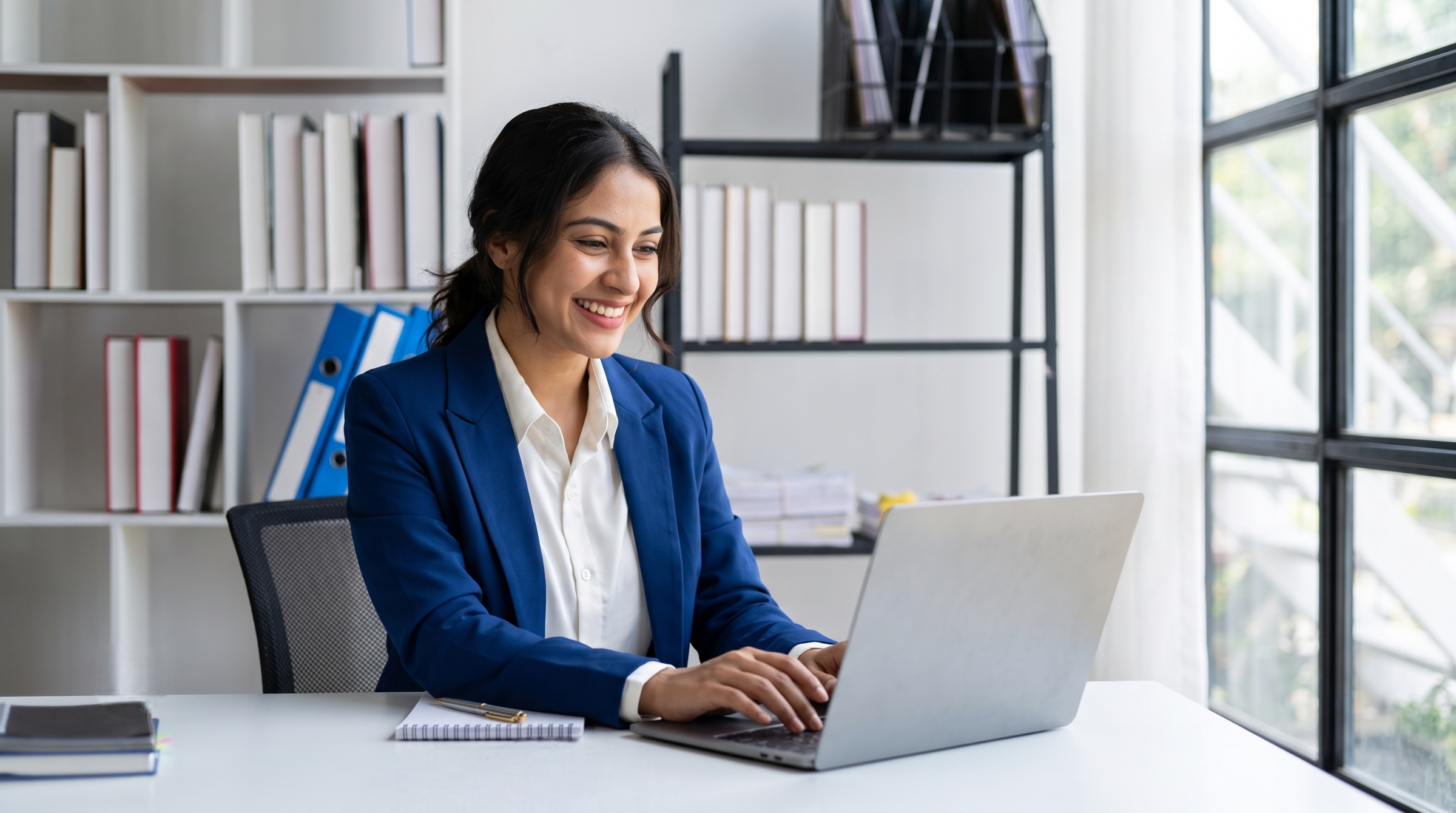 Professional outsourcing governance officer in India analyzing data on a laptop