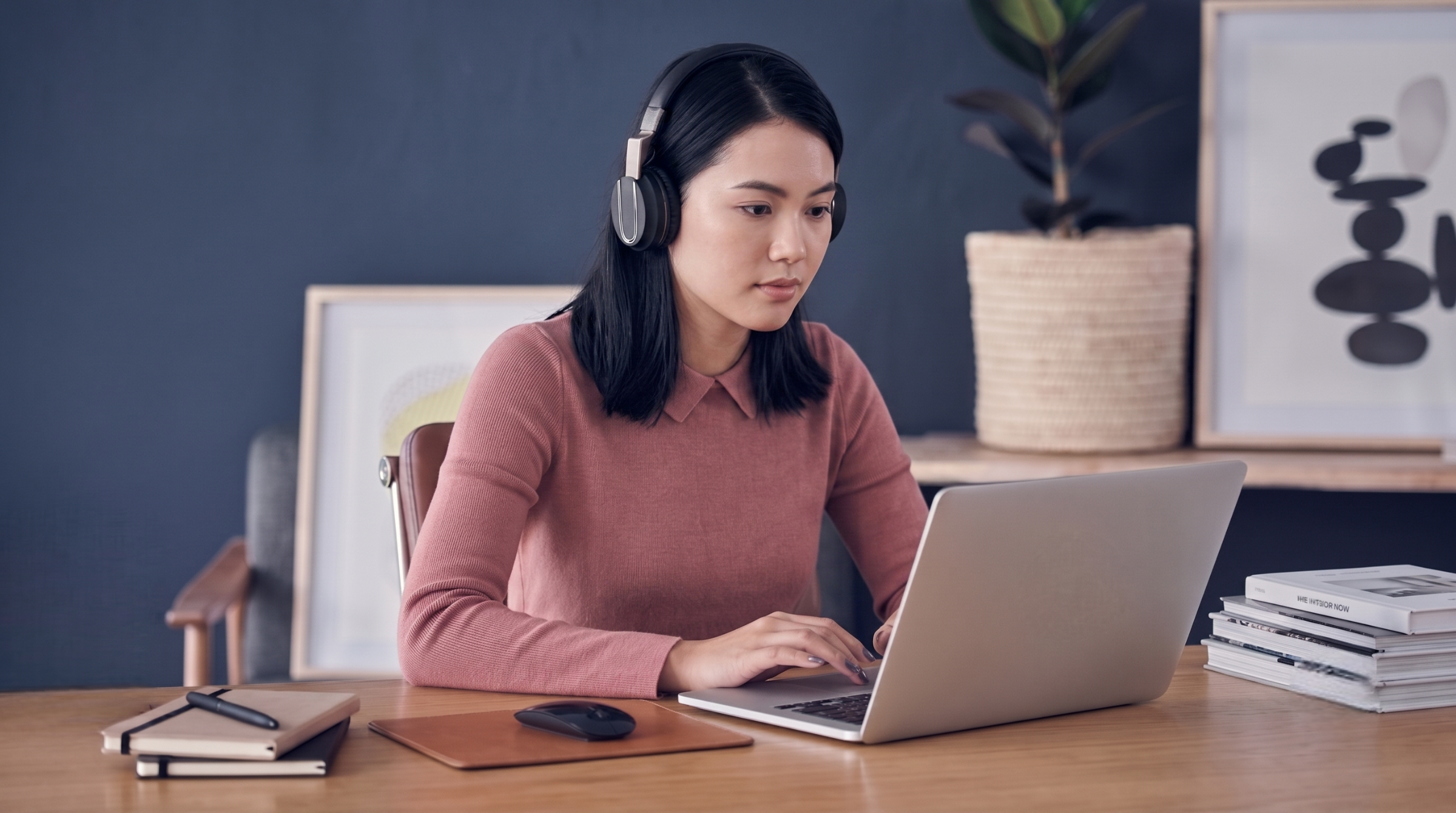 outsource quality control analyst with headphones working on a laptop from a home office