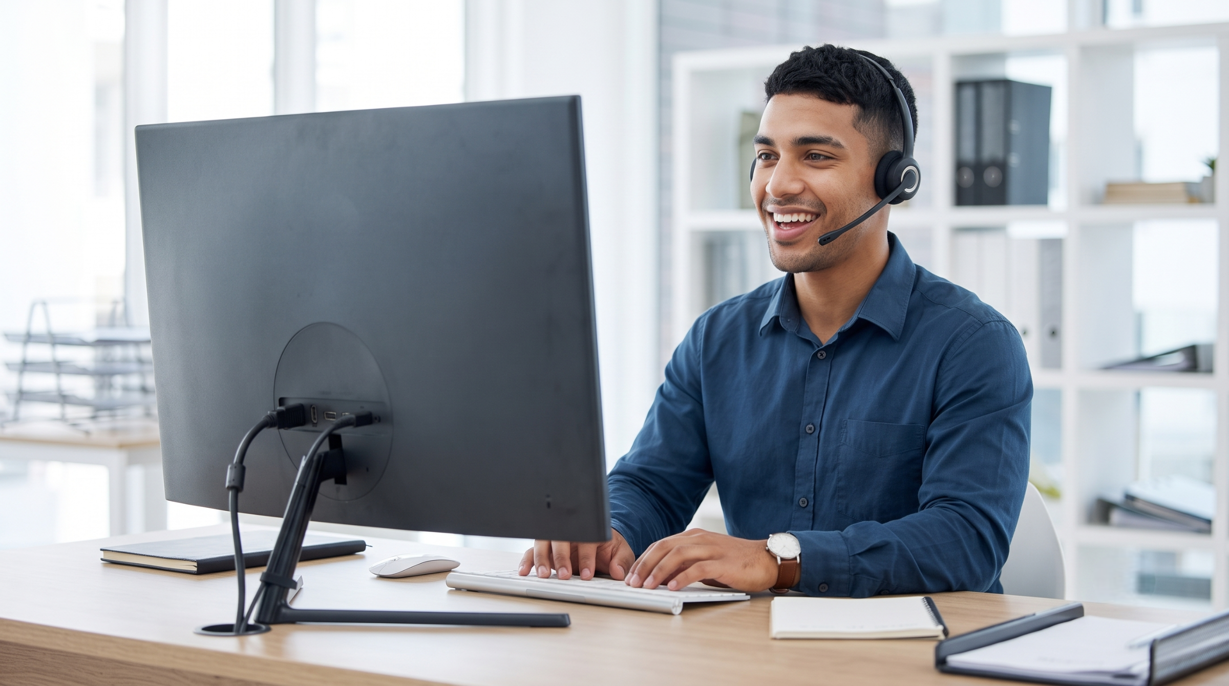 Outsource service desk analyst typing on keyboard and taking support calls