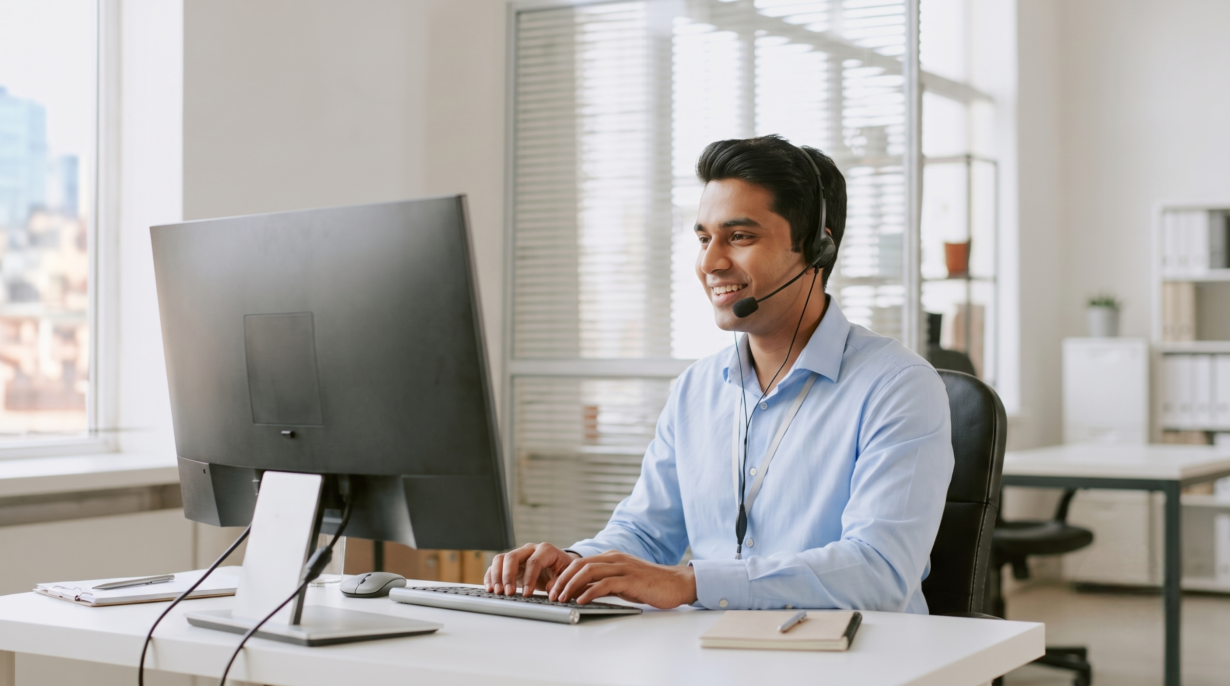 Service desk analyst remote assisting clients on computer wearing headset