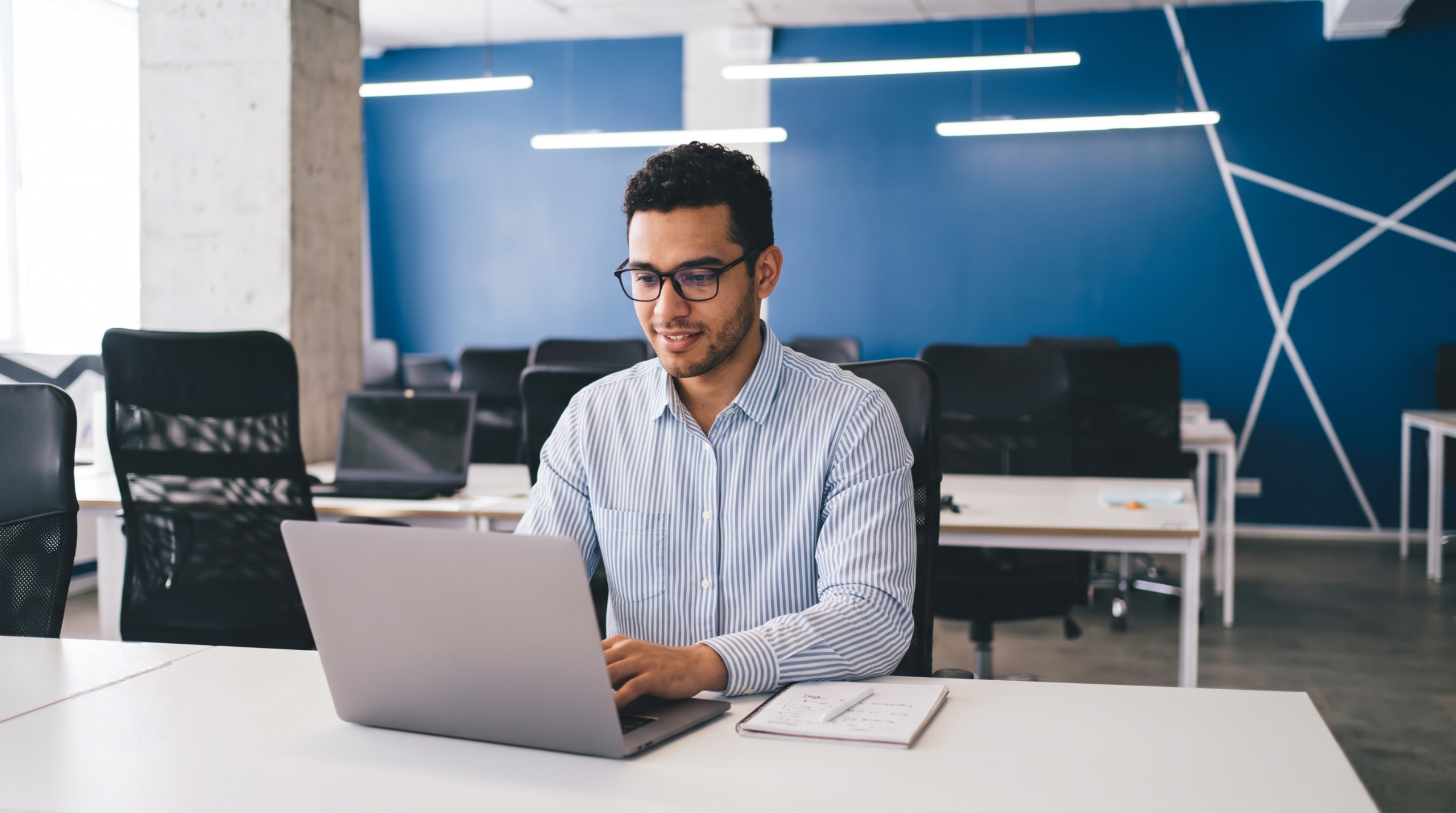 smiling professional working on a laptop, representing global talent acquisition outsourcing solutions
