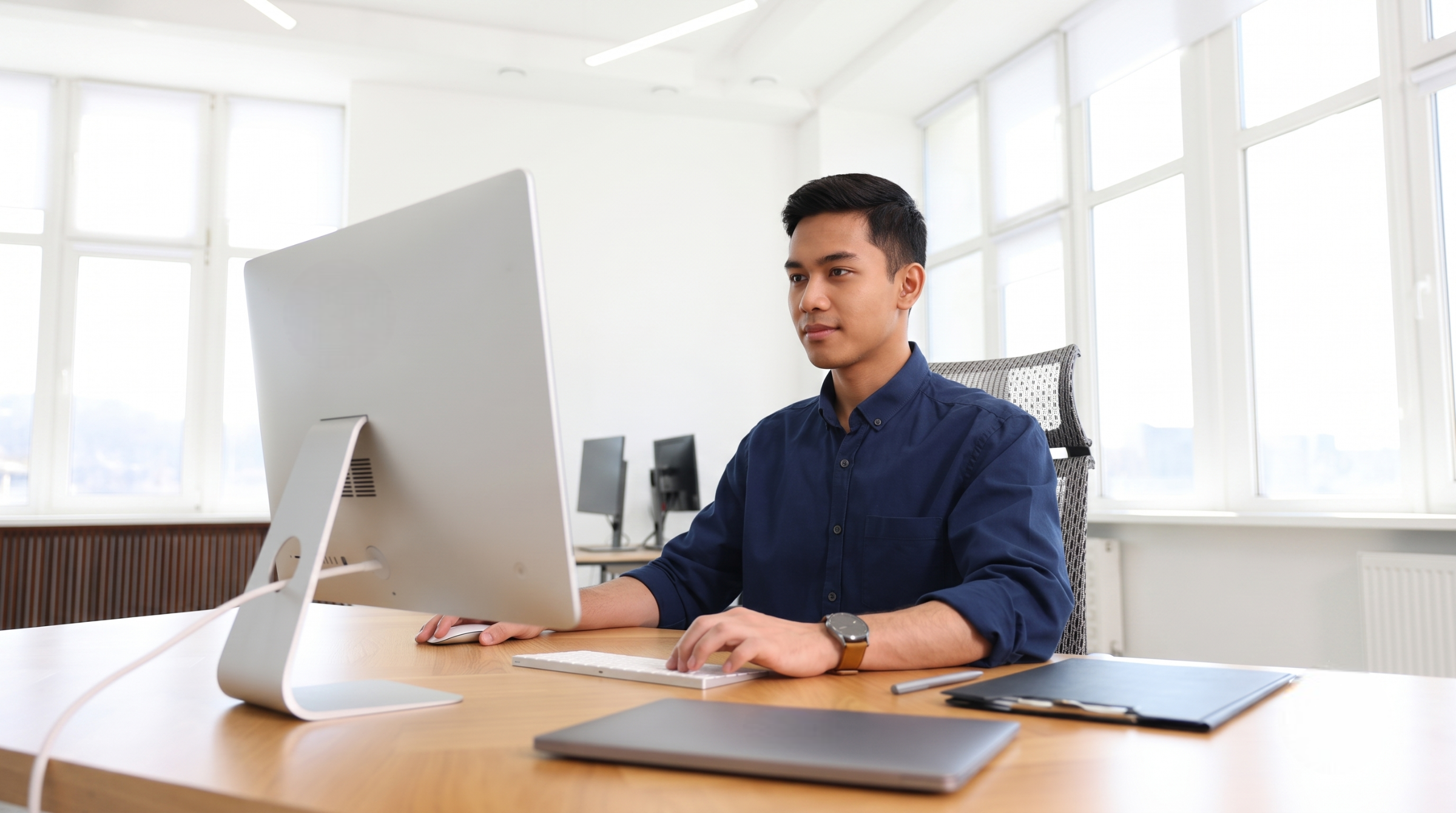 professional managing talent acquisition outsourcing services at a desktop computer in a bright office space
