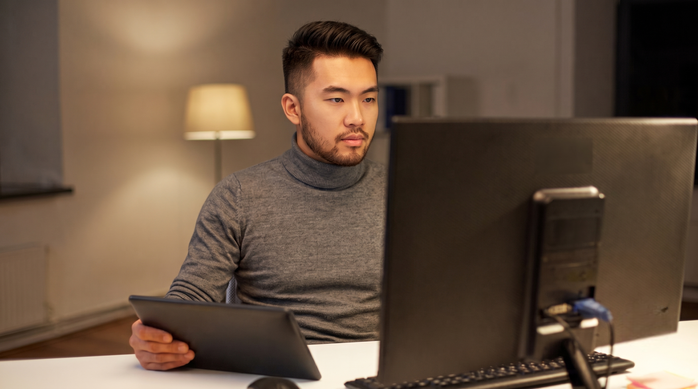 A virtual platform engineer reviewing technical infrastructure on a computer and tablet