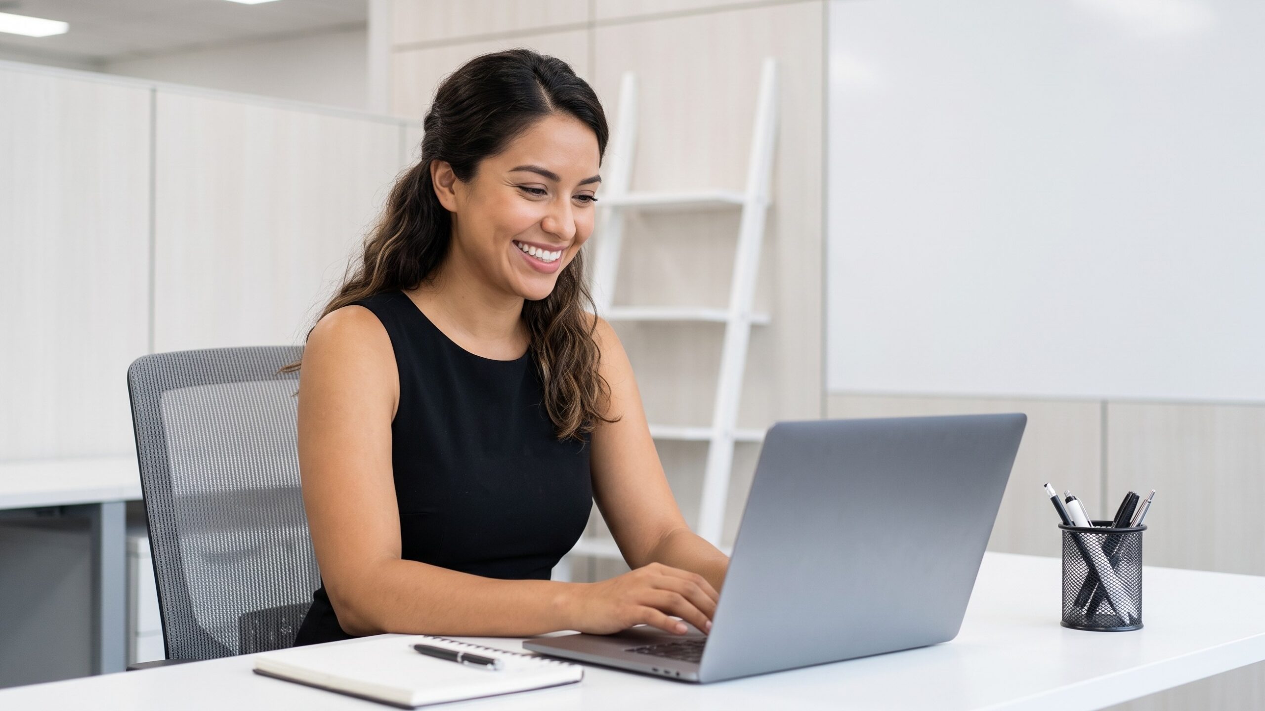 remote media coordinator smiling and working at a modern office desk