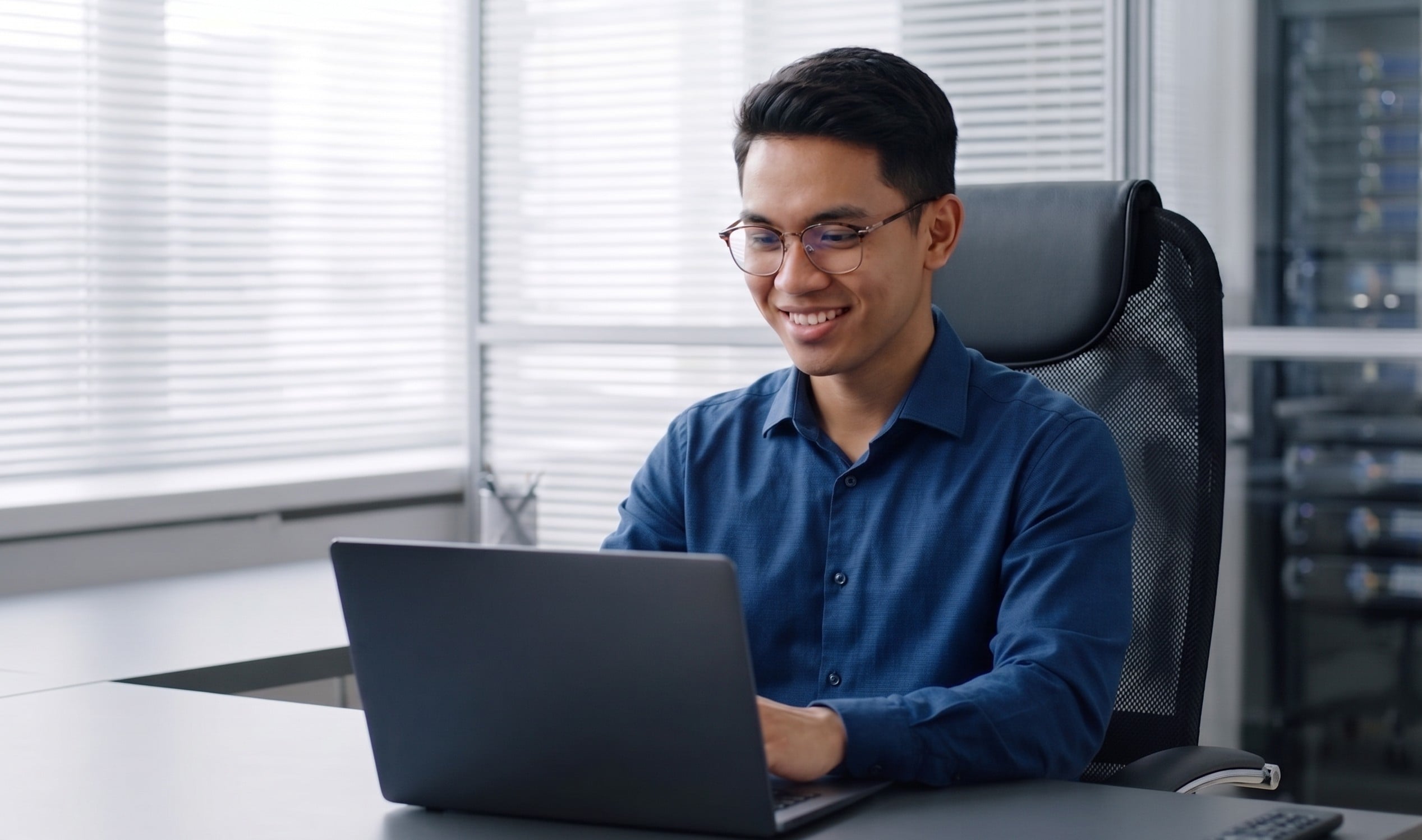 Asian male software engineer at desk coding on a laptop, representing certified .NET developers