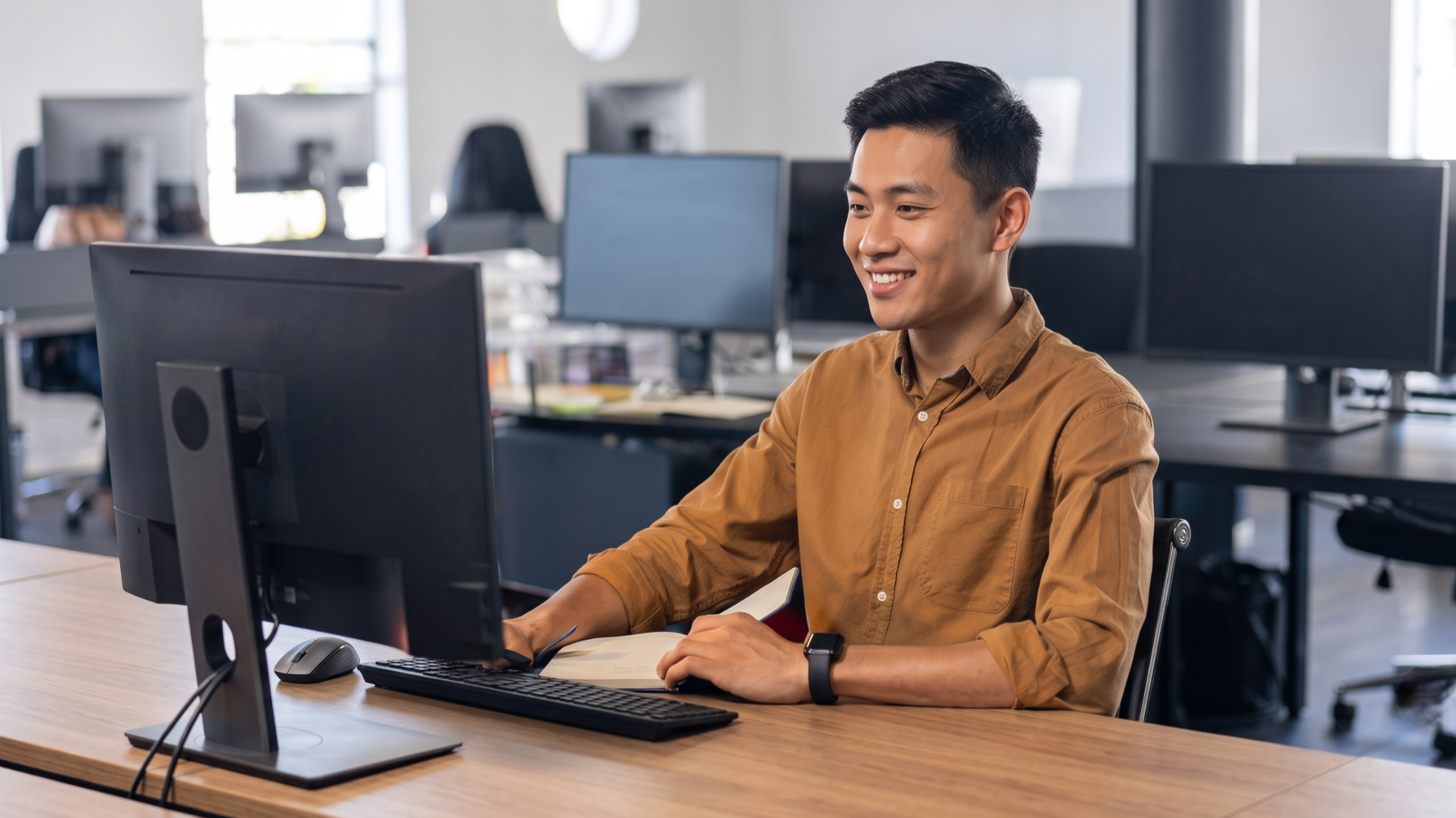 Remote analytics engineer developing solutions from an open-plan office