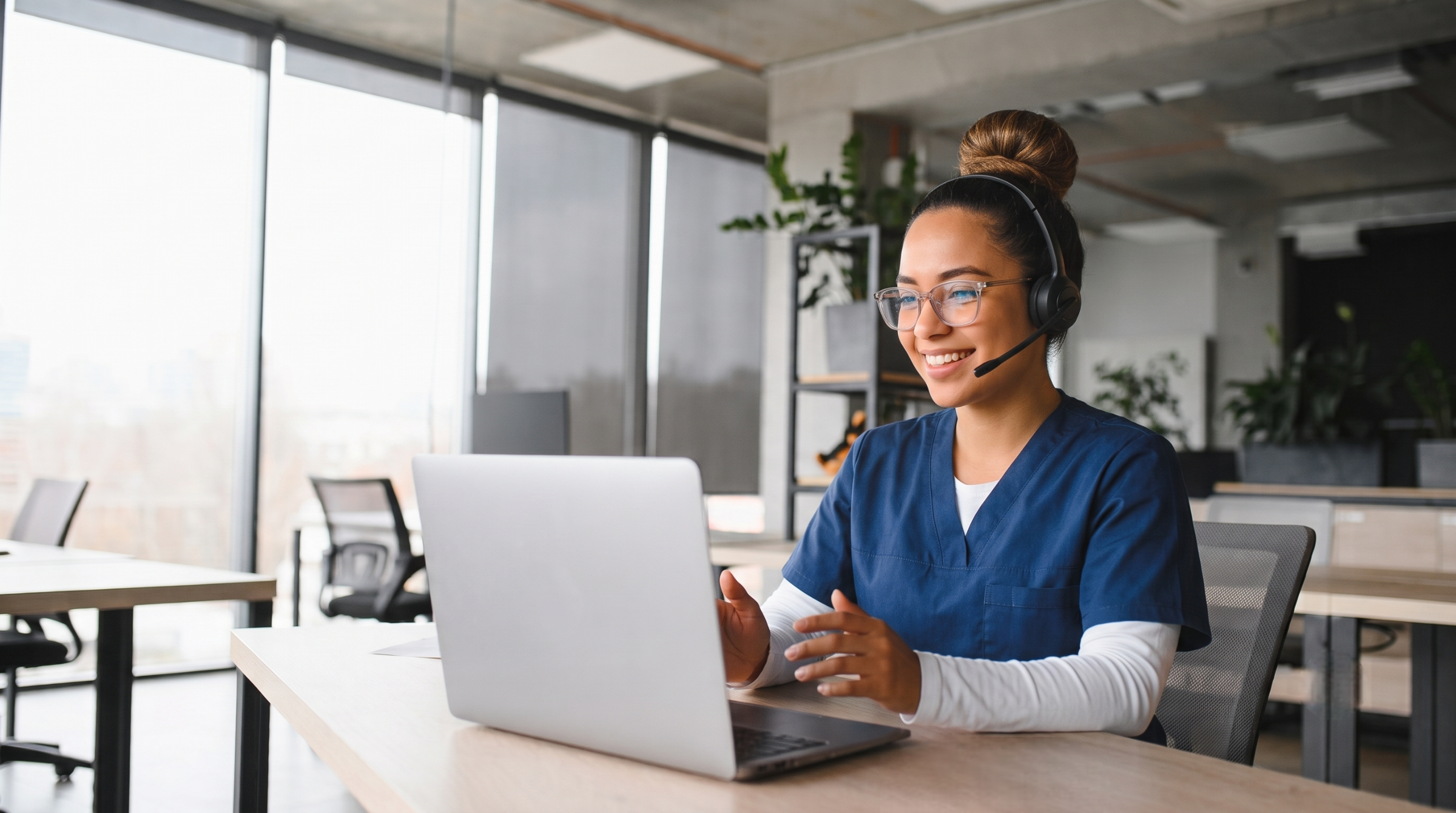 Latina telemedicine patient navigator in dark blue scrubs providing remote care support