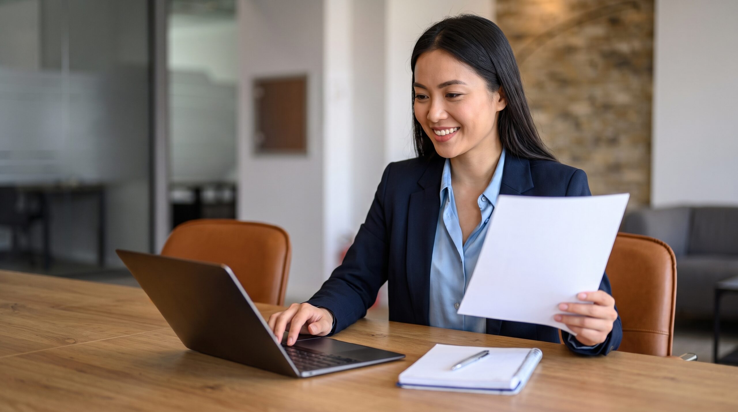 Female remote management accountant in Vietnam working on a laptop at her desk