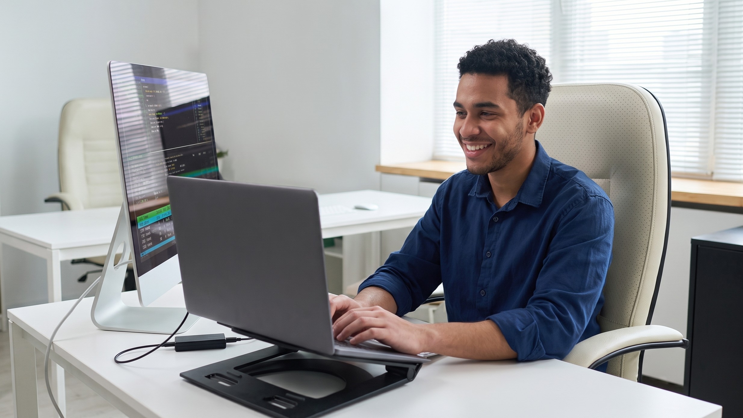 IT systems analyst staffing solution featuring a male professional coding on a laptop and monitor setup