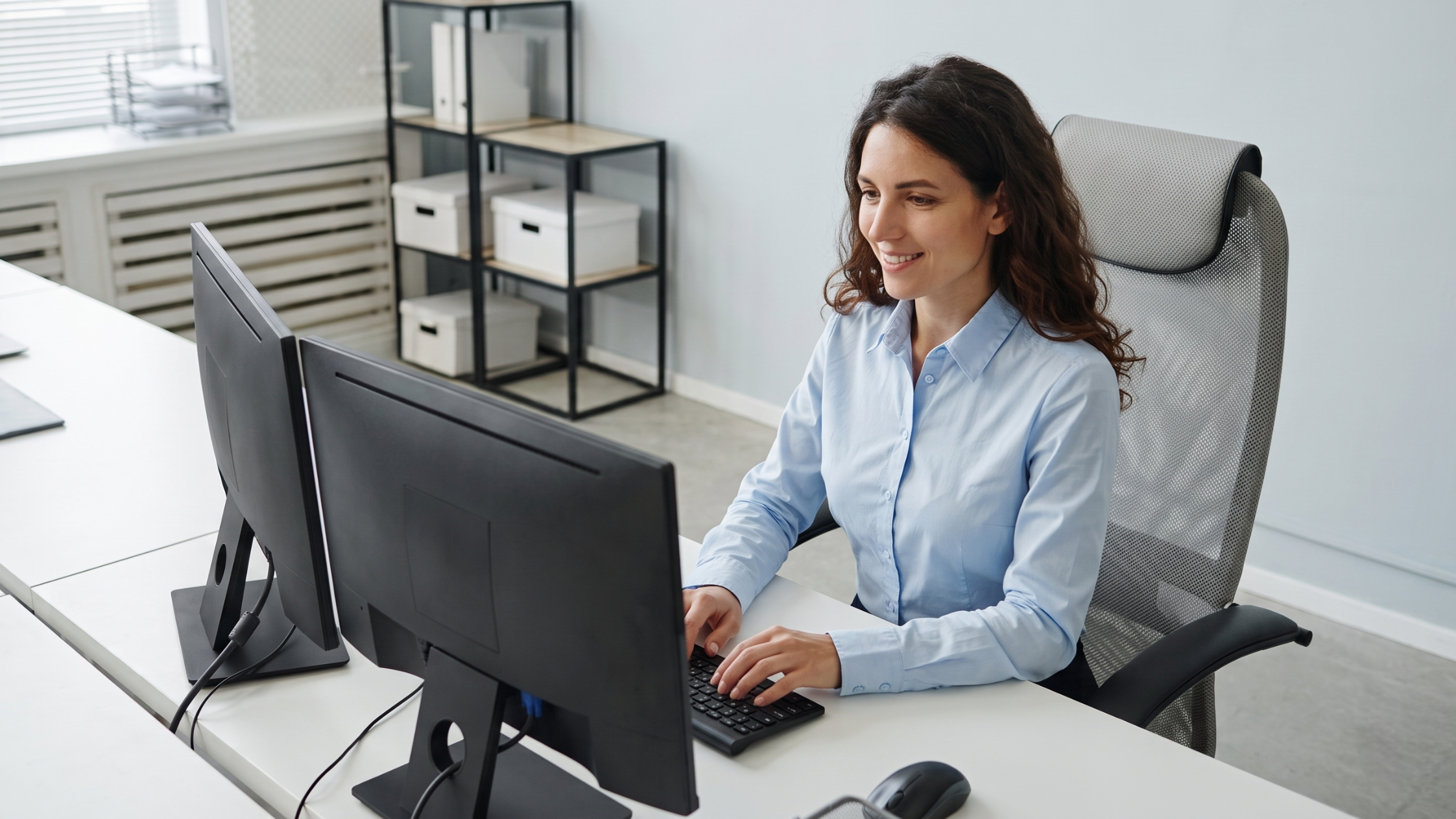 soc analyst remote monitoring security on dual screens in a modern office
