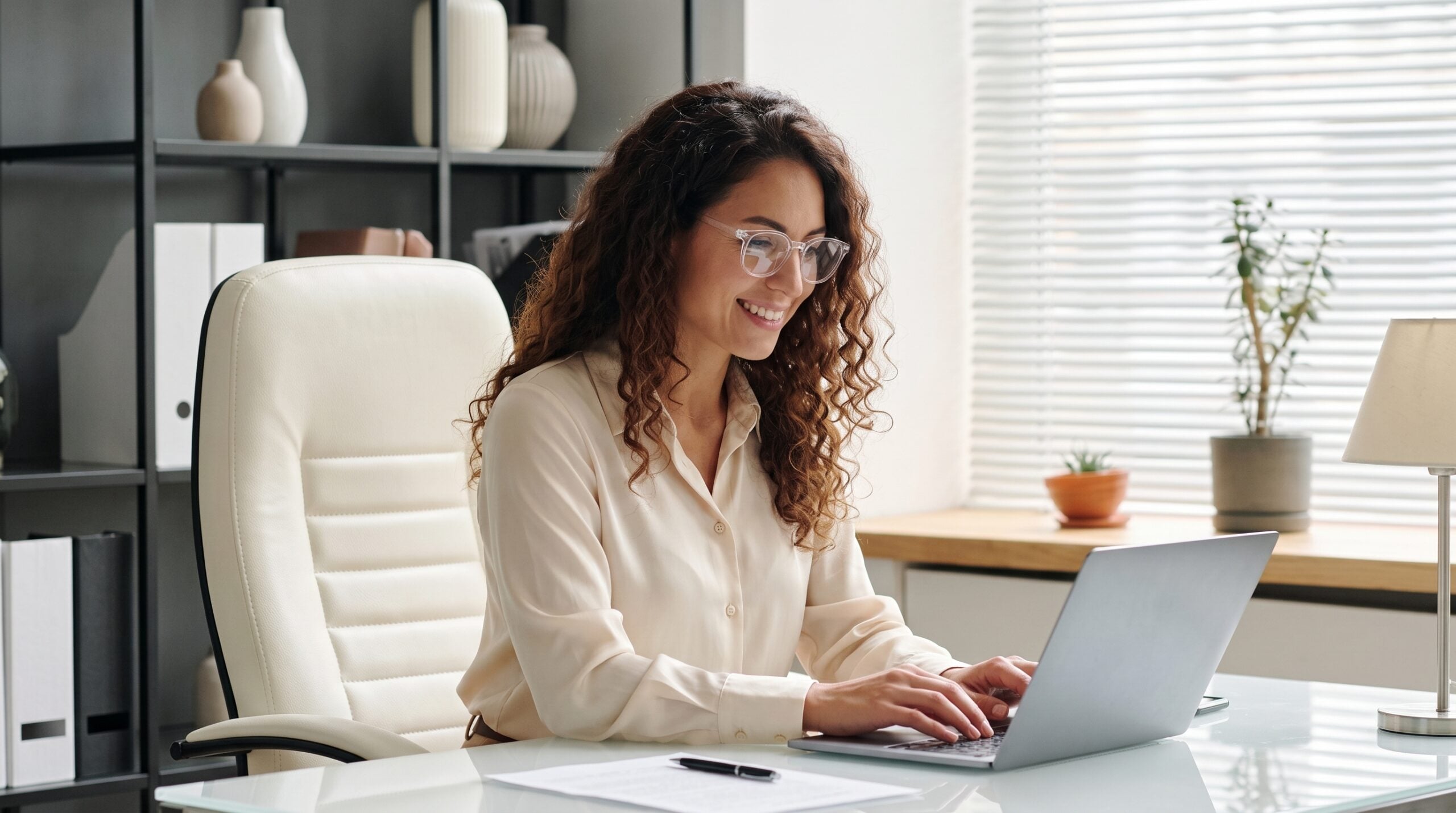 Latina student admissions officer handling remote student enrolment from her office laptop