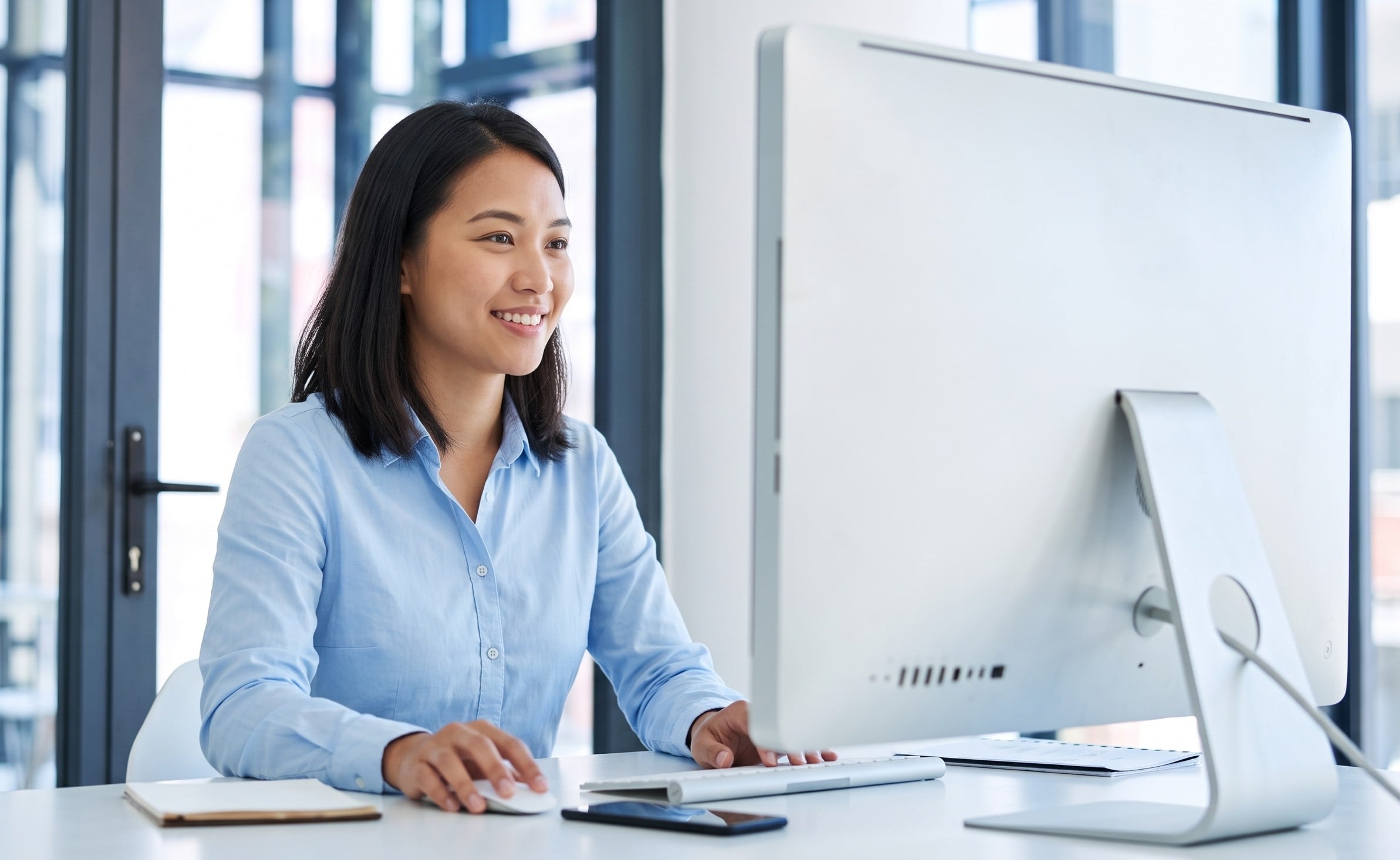 An offshore sales engineer working intently at a desktop computer workstation